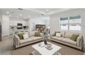 Bright living room with two sofas, modern decor, and an open floor plan leading to the kitchen and dining area at 3952 Big Sky Dr, Spring Hill, FL 34604