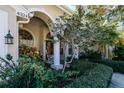 Inviting front porch with rocking chair, lush landscaping, and a double door entry at 4324 Auston Way, Palm Harbor, FL 34685