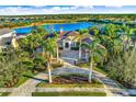 Luxury estate home with a lake view, lush landscaping, and a large backyard at 8376 Catamaran Cir, Lakewood Ranch, FL 34202