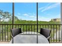 Screened-in patio with table and chairs overlooking lush greenery at 900 Cove Cay Dr # 2B, Clearwater, FL 33760