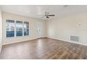 Bright living room with large windows, wood-look flooring, and ceiling fan at 9201 40Th N Way, Pinellas Park, FL 33782