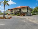 Two-story condo building with Spanish tile roofs, ample parking, and lush landscaping at 1515 Pinellas Bayway S # 40, St Petersburg, FL 33715