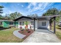 Front yard features curb appeal with landscaping and a gray walkway at 2014 E Genesee St, Tampa, FL 33610