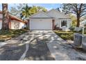 Charming one-story home with white siding, a brick base, and a spacious driveway at 2233 Springwood W Cir, Clearwater, FL 33763