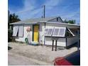 Quaint beach cottage with yellow door and white shutters at 27 80Th Ave, Treasure Island, FL 33706