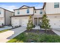 Two-story townhome with attached garage and neatly landscaped front yard at 31386 Amberview Bnd, Wesley Chapel, FL 33545