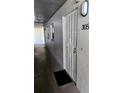 View of unit 305's entrance with secure white metal door and black door mat at 4500 37Th S St # 27, St Petersburg, FL 33711