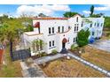 White two-story house with a terracotta roof and landscaped yard at 671 Jasmine S Way, St Petersburg, FL 33705