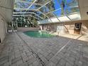 An oval pool in a screened enclosure, surrounded by a paver deck at 12308 N 52Nd St, Temple Terrace, FL 33617