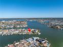 Stunning aerial view of a waterfront property surrounded by lush greenery and sparkling blue water at 15 Marina Ter, Treasure Island, FL 33706