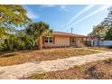 Tan brick ranch home with red shutters and a stone walkway at 2621 13Th N St, St Petersburg, FL 33704