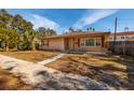 Tan brick ranch home with red shutters and a spacious lawn at 2621 13Th N St, St Petersburg, FL 33704