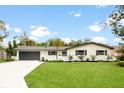 Ranch-style home with white brick exterior, gray roof, and a well-maintained lawn at 6761 15Th N Ave, St Petersburg, FL 33710