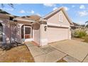 Pink stucco house with a two-car garage and a fenced yard at 1202 Sawdust Ct, Valrico, FL 33596