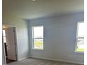 Bright bedroom featuring two large windows providing ample natural light, with plush carpeting at 16025 7Th E Ave, Bradenton, FL 34212