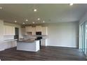 Open-concept kitchen with stainless appliances, granite island, connecting to the living area with hardwood floors at 16025 7Th E Ave, Bradenton, FL 34212