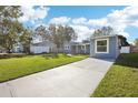 Newly renovated light blue house with a large yard and driveway at 2537 Martha Ln, Land O Lakes, FL 34639