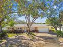 House exterior showcasing a ranch-style home with a large yard and mature trees at 4780 Butterfly Ne Pl, St Petersburg, FL 33703
