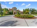 Mediterranean style home with a fountain and lush landscaping at 7713 Still Lakes Dr, Odessa, FL 33556