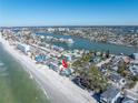 Wide aerial showcasing beachfront home, neighborhood, and surrounding waterways at 8406 W Gulf Blvd, Treasure Island, FL 33706