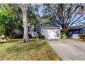 Cute light gray exterior with a white door and attached garage at 1034 Willowood Ln, Dunedin, FL 34698