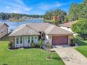 Single-story home with lake view, stone accents and a paved driveway at 12520 Shadow Ridge Blvd, Hudson, FL 34669