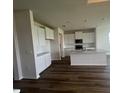 Modern kitchen featuring white cabinetry, stainless steel appliances, and dark wood flooring throughout at 16017 7Th E Ave, Bradenton, FL 34212