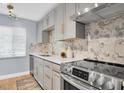 Modern kitchen with stainless steel appliances, custom grey cabinets, and a unique marble backsplash at 2060 Marilyn St # 241, Clearwater, FL 33765
