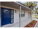 Front entrance with a new blue door and stonework at 7151 Pinewood Dr, New Port Richey, FL 34652