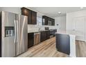 Well-lit kitchen with stainless steel appliances and dark cabinetry at 10541 Hidden Banks Gln, Parrish, FL 34219