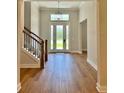 Inviting foyer with wood-look flooring, staircase and a large front door with glass inserts at 13400 Haflinger Way, Hudson, FL 34667