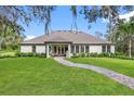 Private backyard oasis with a paved pathway and lush greenery at 13430 Haflinger Way, Hudson, FL 34667