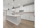 Modern kitchen with white cabinets, quartz countertops, and stainless steel appliances at 1532 Gopher Loop, Tarpon Springs, FL 34689