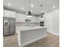 Modern kitchen with white cabinets, quartz countertops, and stainless steel appliances at 1532 Gopher Loop, Tarpon Springs, FL 34689
