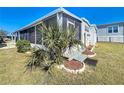 White mobile home with a screened porch and landscaping at 162 S Saint Thomas Cir, Apollo Beach, FL 33572