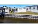 Waterfront view of a white mobile home with seawall at 162 S Saint Thomas Cir, Apollo Beach, FL 33572