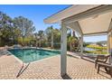 Community pool with a covered patio area and lounge chairs at 2044 Sheffield Ct, Oldsmar, FL 34677