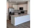 Bright kitchen featuring white cabinets, stainless steel appliances, and a large island at 4588 Pleasant Ave, Palm Harbor, FL 34683
