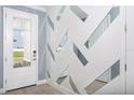 Modern entryway with geometric mirrored accent wall and tile flooring at 12158 Meditation Trl, Venice, FL 34293