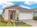 Beautiful home with a brick driveway, stone accents, well manicured garden, and a striking orange front door at 12170 Meditation Trl, Venice, FL 34293