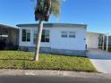 Front view of a white manufactured home with a palm tree in the yard at 13225 101St St # 451, Largo, FL 33773