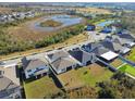 A neighborhood featuring single-Gathering homes with well-maintained lawns, a pond, and community amenities at 21291 Snowy Orchid Ter, Land O Lakes, FL 34637