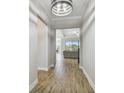 Inviting hallway showcasing wood-look tile floors and open access to the living spaces at 21291 Snowy Orchid Ter, Land O Lakes, FL 34637