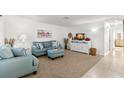 Inviting living room with neutral carpet, blue furniture, and a charming beach-themed artwork at 2232 Greenwich Dr # 56, Sun City Center, FL 33573