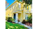 Two-story yellow house with green door and landscaping at 2564 Hidden Cove Ln, Clearwater, FL 33763