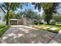 Home with a long driveway leading to a carport and a well maintained lawn at 2934 W Coachman Ave, Tampa, FL 33611