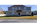 Front view of a two-story townhome with gray siding and landscaping at 31225 Claridge Pl, Wesley Chapel, FL 33543
