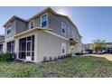 Side view of a two-story townhome with gray siding and screened porch at 31225 Claridge Pl, Wesley Chapel, FL 33543