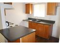 Galley kitchen with wood cabinets, dark countertops, and appliances at 4215 E Bay Dr # 1202C, Clearwater, FL 33764
