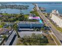 Aerial view of condo building, emphasizing its proximity to the water and bridge at 55 Harbor View Ln # 301, Belleair Bluffs, FL 33770